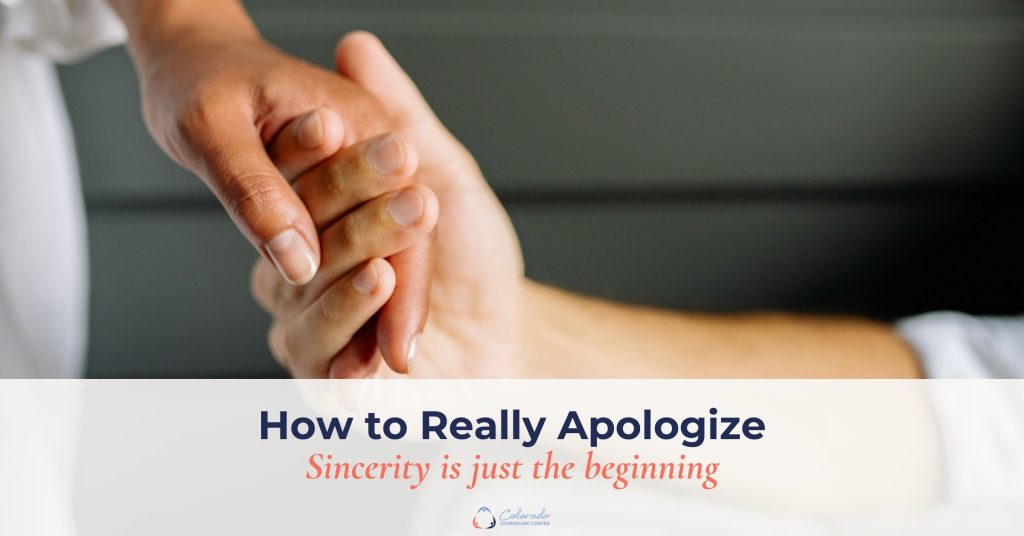 Couple holding hands after apologizing and repairing their relationship