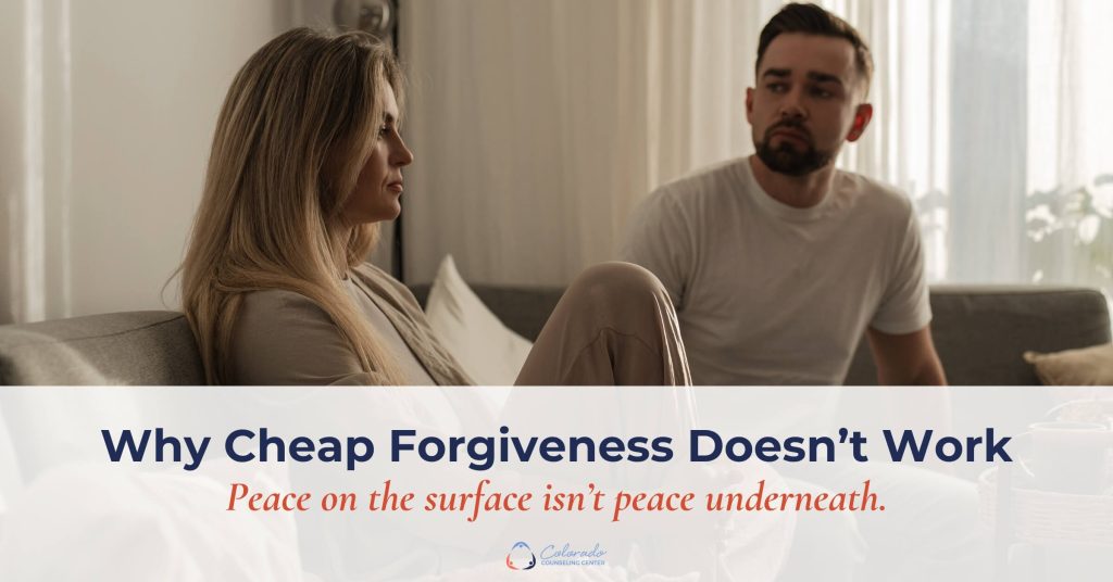 Woman turned away in quiet tension while her partner watches with concern, illustrating the unresolved hurt beneath cheap forgiveness or counterfeit forgiveness