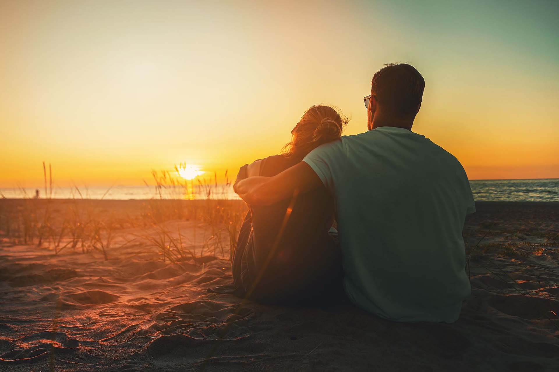 Couple sitting together at sunset, looking toward the horizon — couples counseling in Greenwood Village & Centennial
