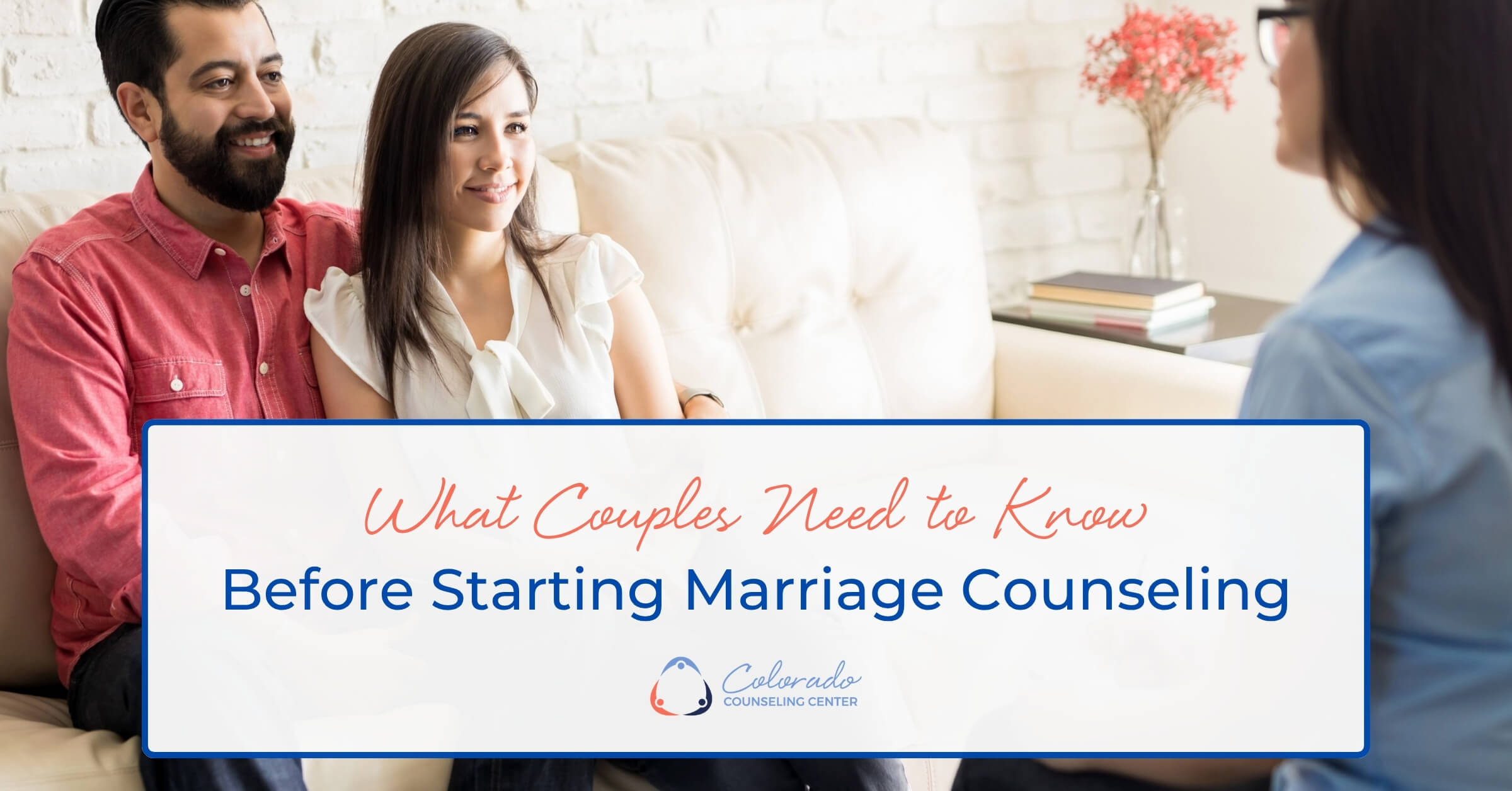 Couple smiling and engaged during a marriage counseling session with their therapist