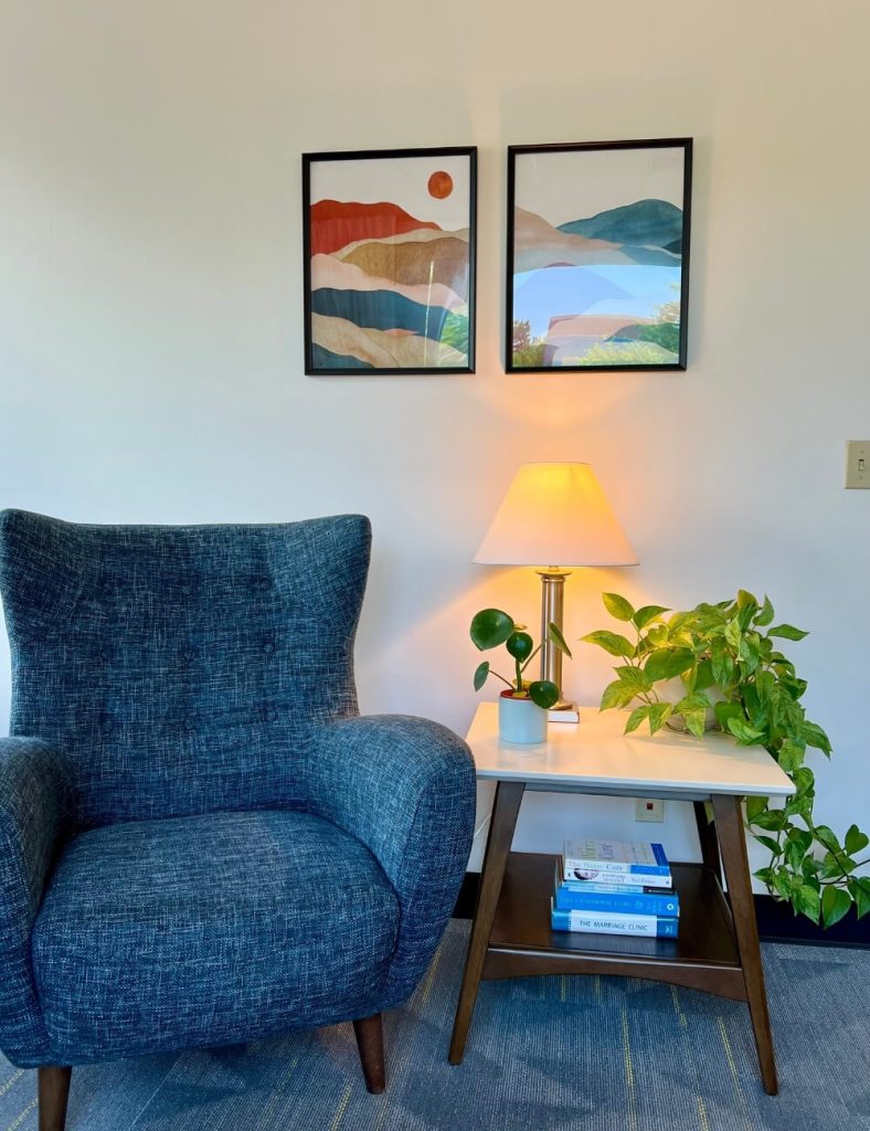 Inviting detail of a counseling space at Colorado Counseling Center, with a soft armchair, table lamp, and greenery