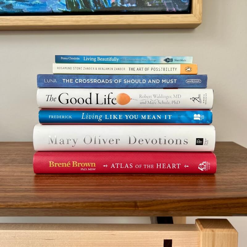 Stack of therapist-recommended books on emotional growth and healing at Colorado Counseling Center in Greenwood Village