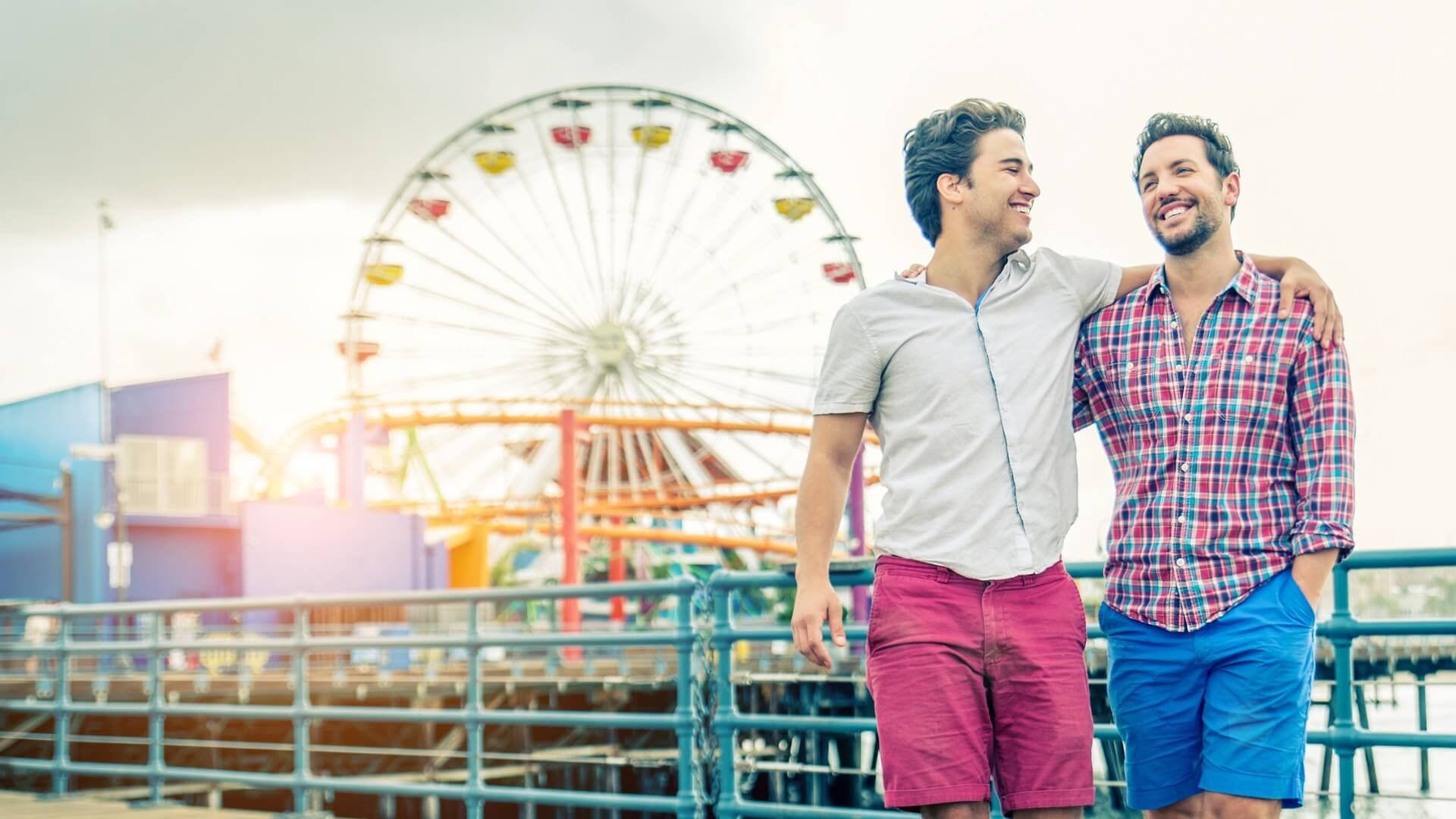 Two men smiling and walking arm-in-arm, representing connection in LGBTQ+ couples counseling near Greenwood Village & Centennial